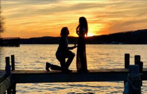 A wedding proposal over the water during a sunset